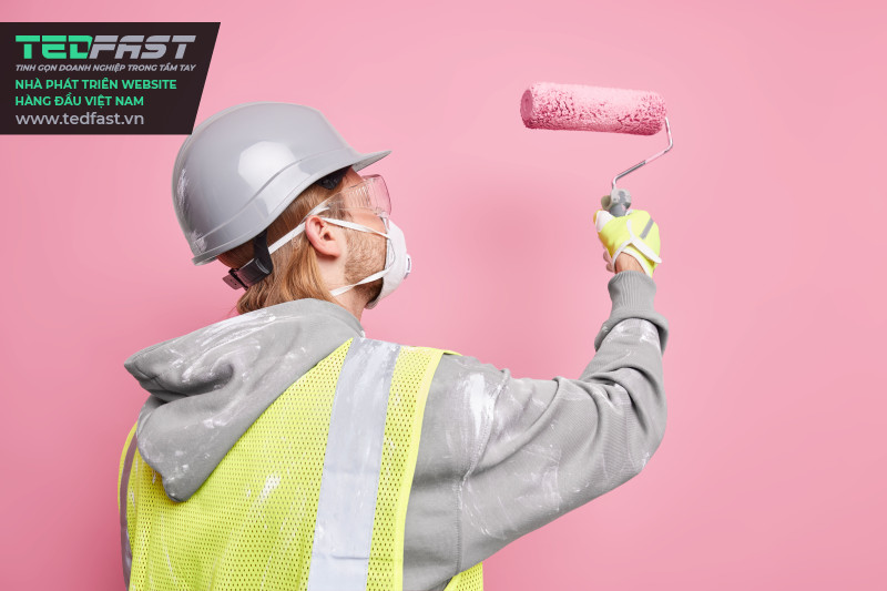 Hình ảnh một người thợ sơn đang biến đổi bức tường sang màu hồng