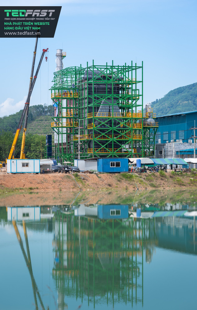 Hình ảnh một khu nhà máy đang được xây dựng bên cạnh một bờ hồ